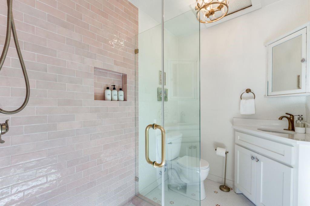 802 Broad Street McKinney, TX 75069 - Photo 8 of 12 a bathroom with a granite countertop toilet sink and mirror