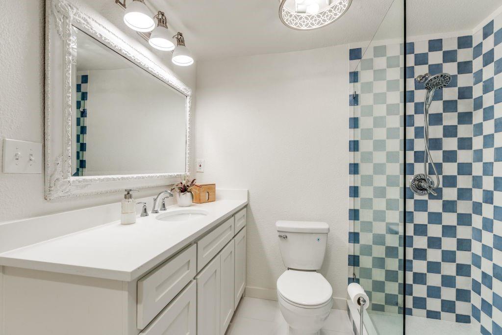 802 Broad Street McKinney, TX 75069 - Photo 10 of 12 a bathroom with a sink a toilet and a mirror
