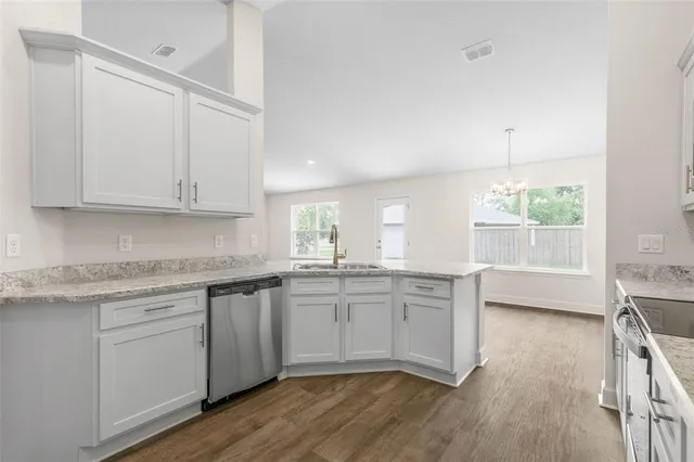 a kitchen with granite countertop white cabinets and white appliances