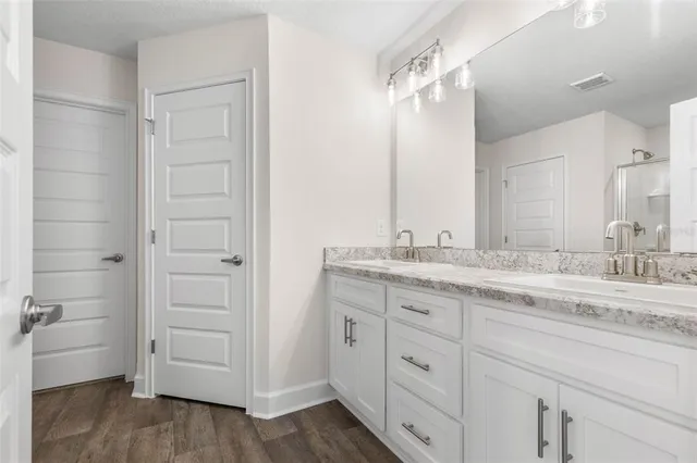 a bathroom with a granite countertop sink mirror and a toilet