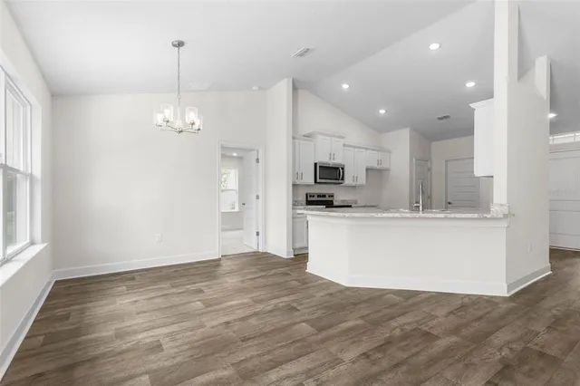 a view of kitchen with stainless steel appliances refrigerator stove microwave and cabinets