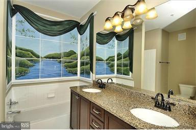 12824 Clarksburg Square Road, Unit 208 Clarksburg, MD 20871 - Photo 10 of 20 a bathroom with a granite countertop sink a mirror and a bathtub