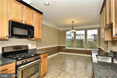 12824 Clarksburg Square Road, Unit 208 Clarksburg, MD 20871 - Photo 6 of 20 a kitchen with sink a stove and microwave