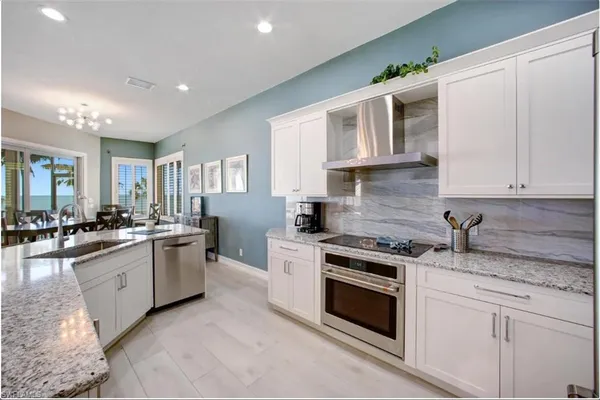a kitchen with stainless steel appliances kitchen island granite countertop a table and chairs in it