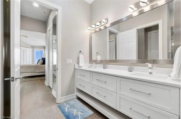 a bathroom with double vanity sinks a toilet a mirror and shower