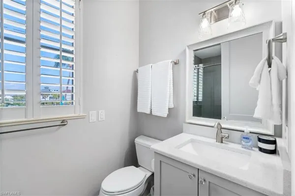 a bedroom with a bed and large windows
