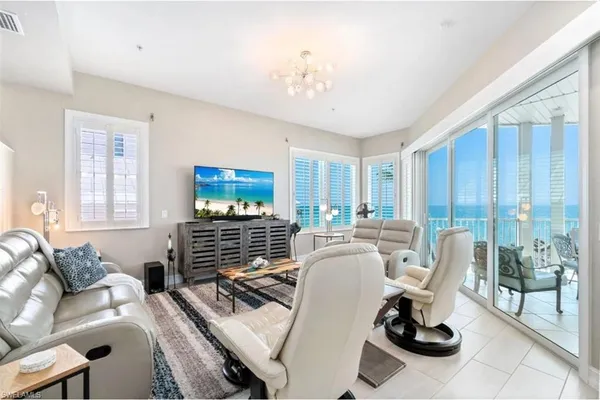 a living room with furniture a flat screen tv and a window