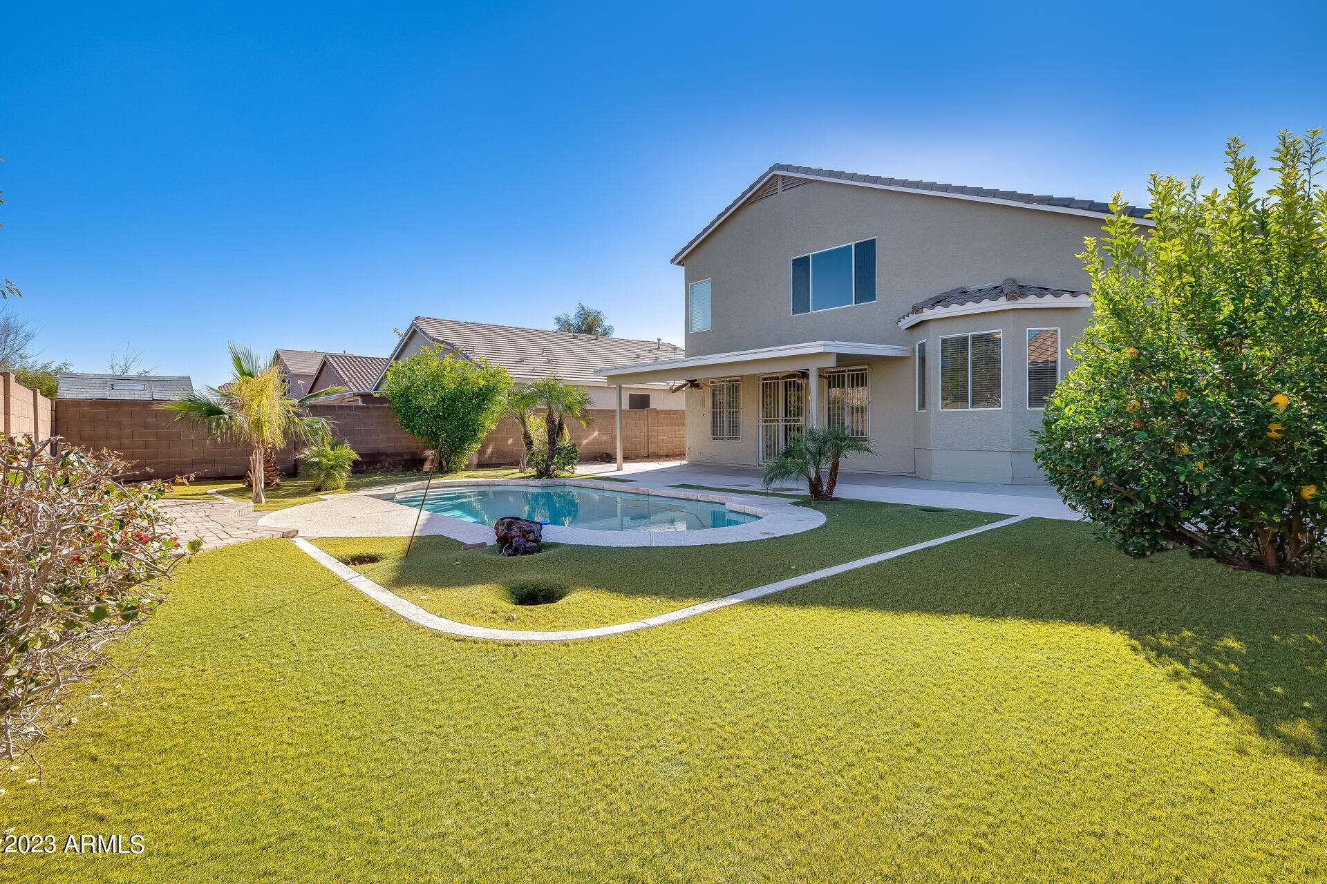 3244 West Maldonado Road Phoenix, AZ 85041 - Photo 42 of 43 a view of a swimming pool with some plants and large trees