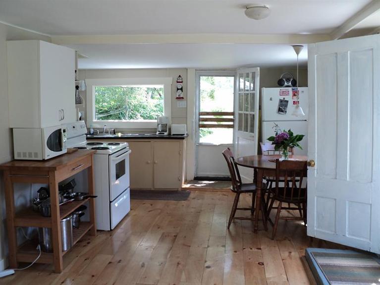4 Pond Road, Unit 1 2 3 Truro, MA 02666 - Photo 15 of 19 a kitchen with a table chairs stove and cabinets