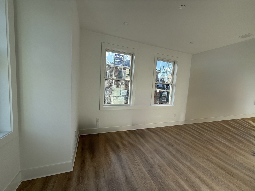 49 Chase Street, Unit 3 Newton, MA 02459 - Photo 10 of 12 a view of an empty room with wooden floor and a window