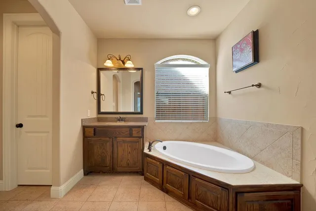 a bathroom with a tub sink and mirror