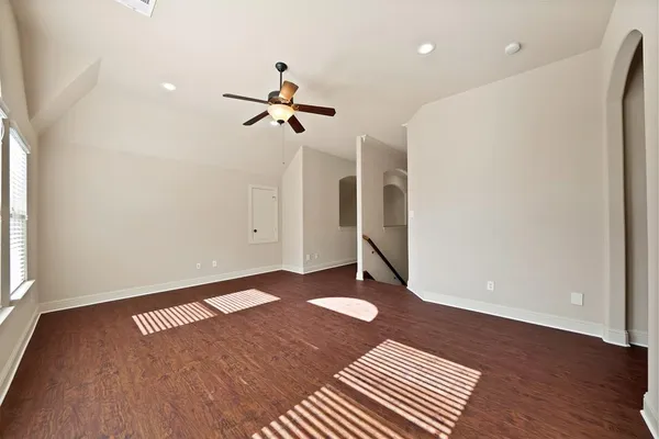 a view of a big room with wooden floor and windows