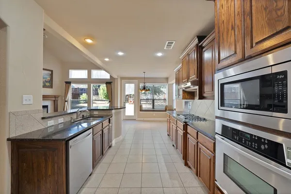 a large kitchen with stainless steel appliances granite countertop a stove and a sink