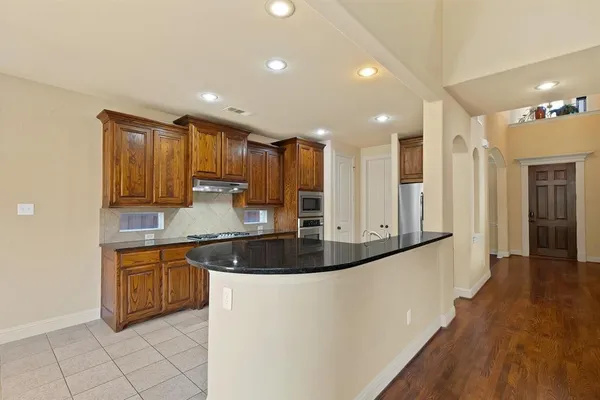a kitchen with stainless steel appliances granite countertop a sink and a stove