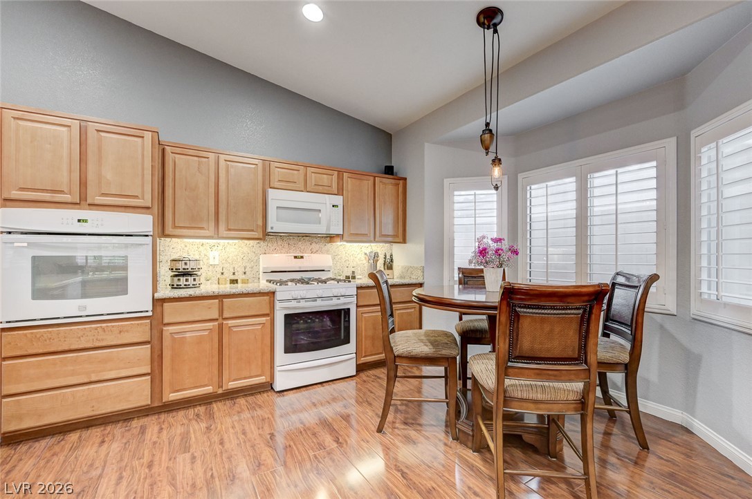 1604 Cattle Ranch Place Henderson, NV 89002 - Photo 21 of 99 A well-appointed kitchen features natural wood cabinetry and a convenient dining area bathed in natural light.