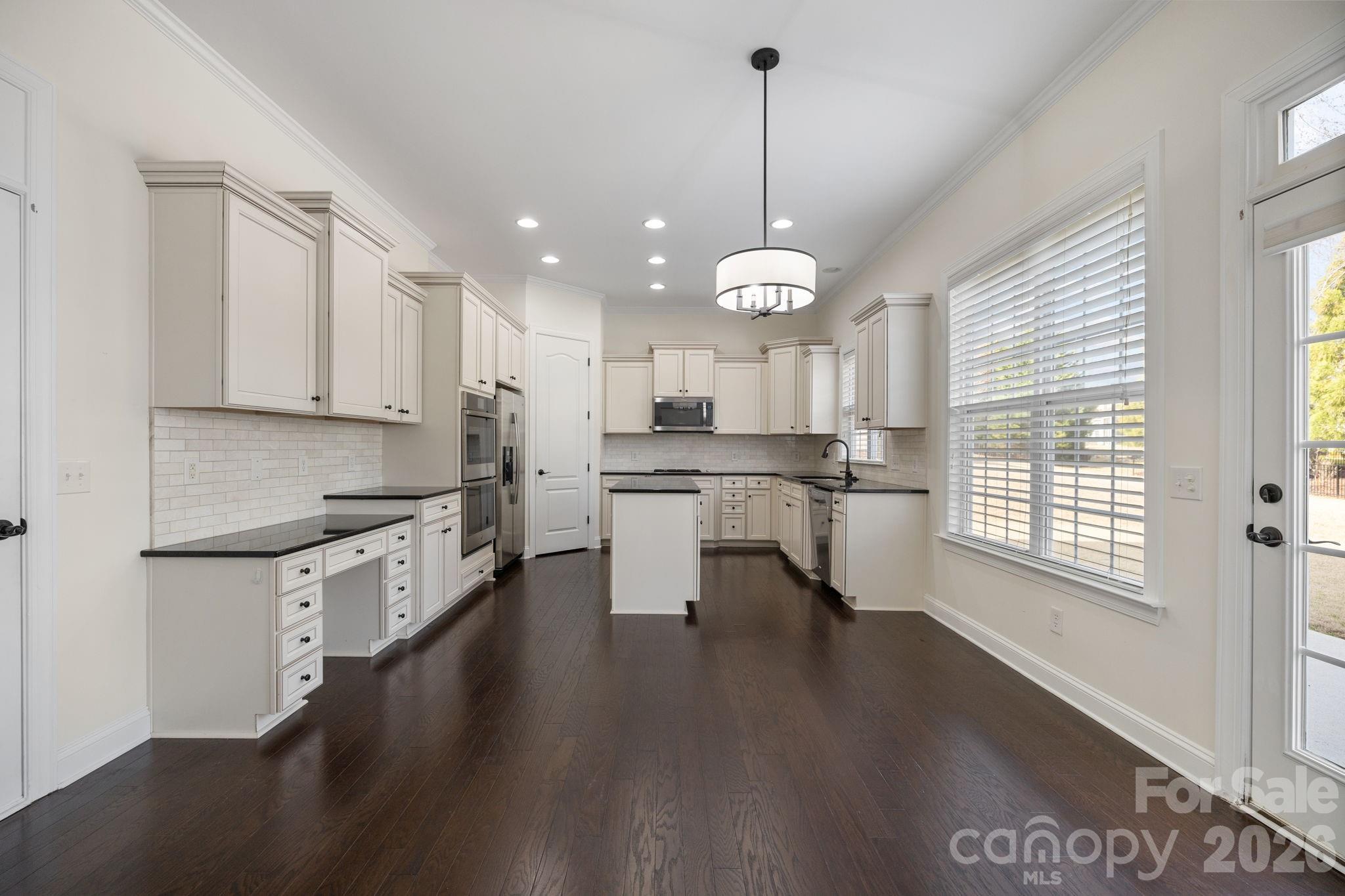 646 Quicksilver Trail Fort Mill, SC 29708 - Photo 14 of 48 a open kitchen with stainless steel appliances granite countertop a stove a sink dishwasher and a wooden floor