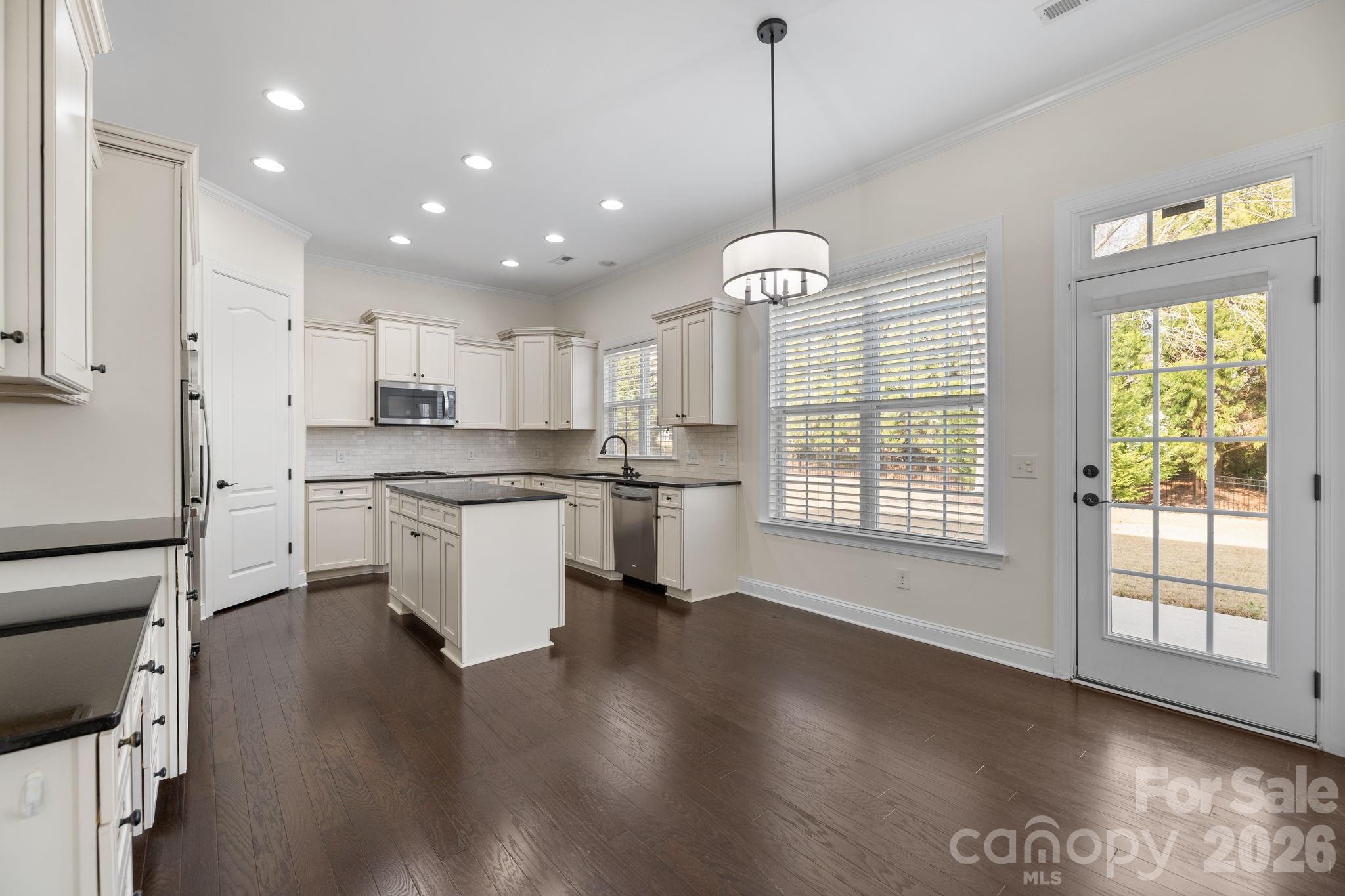 646 Quicksilver Trail Fort Mill, SC 29708 - Photo 15 of 48 a kitchen with stainless steel appliances granite countertop a stove a sink a center island a refrigerator and a wooden floor