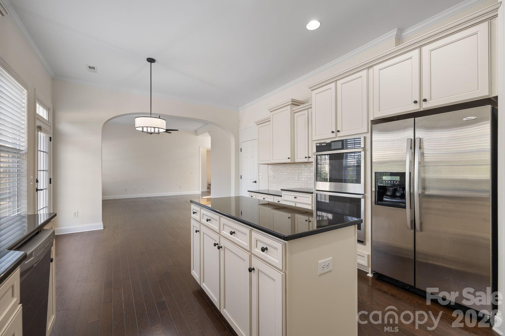 646 Quicksilver Trail Fort Mill, SC 29708 - Photo 19 of 48 a kitchen with stainless steel appliances granite countertop a refrigerator a sink dishwasher a stove and white cabinets with wooden floor