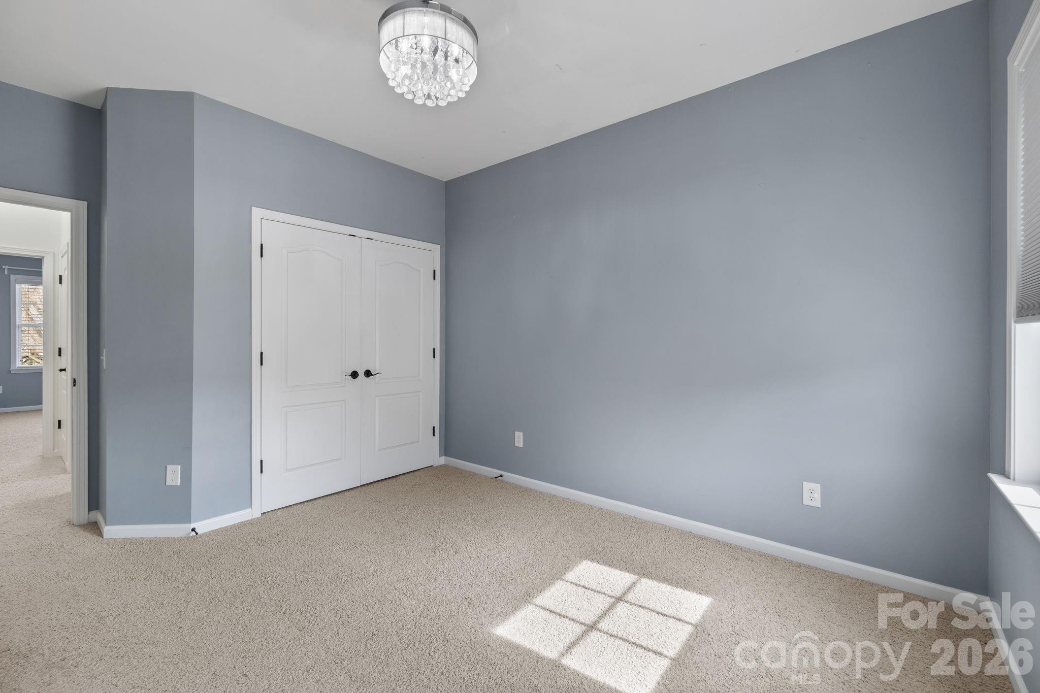 646 Quicksilver Trail Fort Mill, SC 29708 - Photo 30 of 48 an empty room with a chandelier fan and windows
