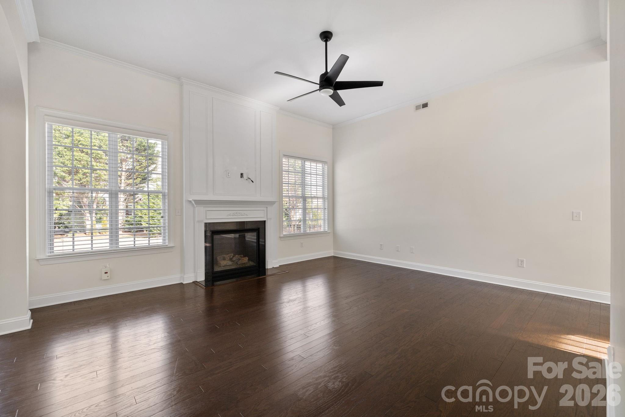 646 Quicksilver Trail Fort Mill, SC 29708 - Photo 9 of 48 an empty room with wooden floor fireplace and windows