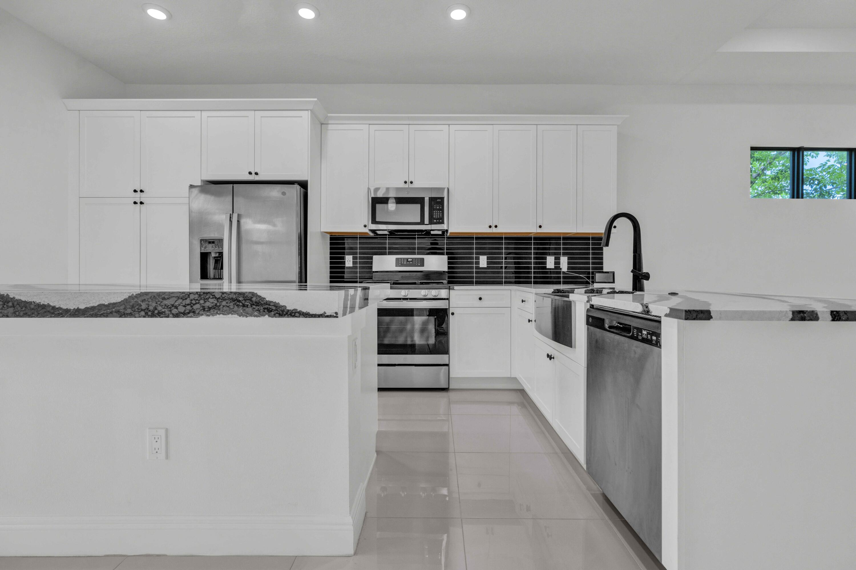 5501 Santa Rosa Lane Westlake, FL 33470 - Photo 9 of 31 a kitchen with stainless steel appliances a refrigerator sink and white stove