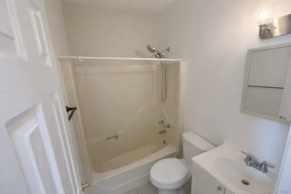 a white toilet sitting next to a bath tub