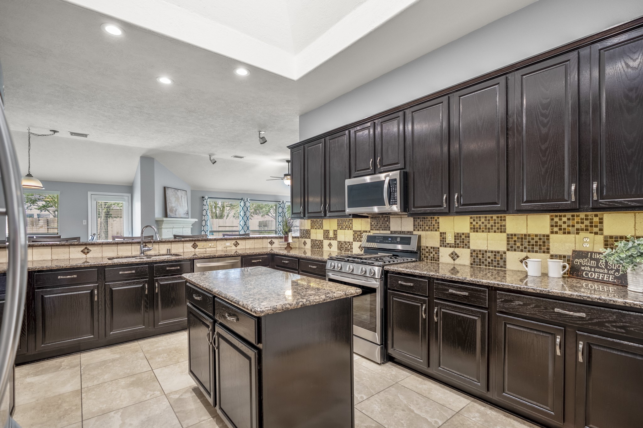 3411 Utah Beach Court Spring, TX 77388 - Photo 12 of 50 Deeper into the kitchen, the amount of workspace and storage really comes into focus, with cabinetry lining the perimeter, sparkling granite counters, and the island centered for extra prep space. Updated hardware, soft-close hinges and drawer slides, and LED recessed lighting add practical upgrades, while the raised bar keeps the kitchen connected to the breakfast room and family room beyond.