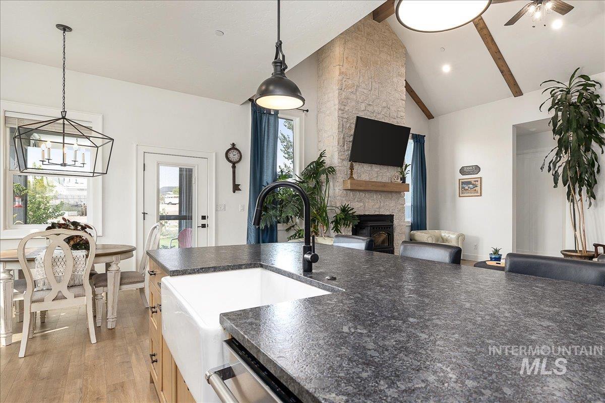 24301 Wanda Way Middleton, ID 83644 - Photo 49 of 50 Kitchen with decorative light fixtures, light wood-style floors, a fireplace, high vaulted ceiling, and open floor plan