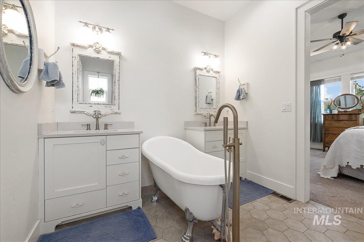 24301 Wanda Way Middleton, ID 83644 - Photo 21 of 50 Ensuite bathroom featuring a soaking tub, light tile patterned floors, and two vanities