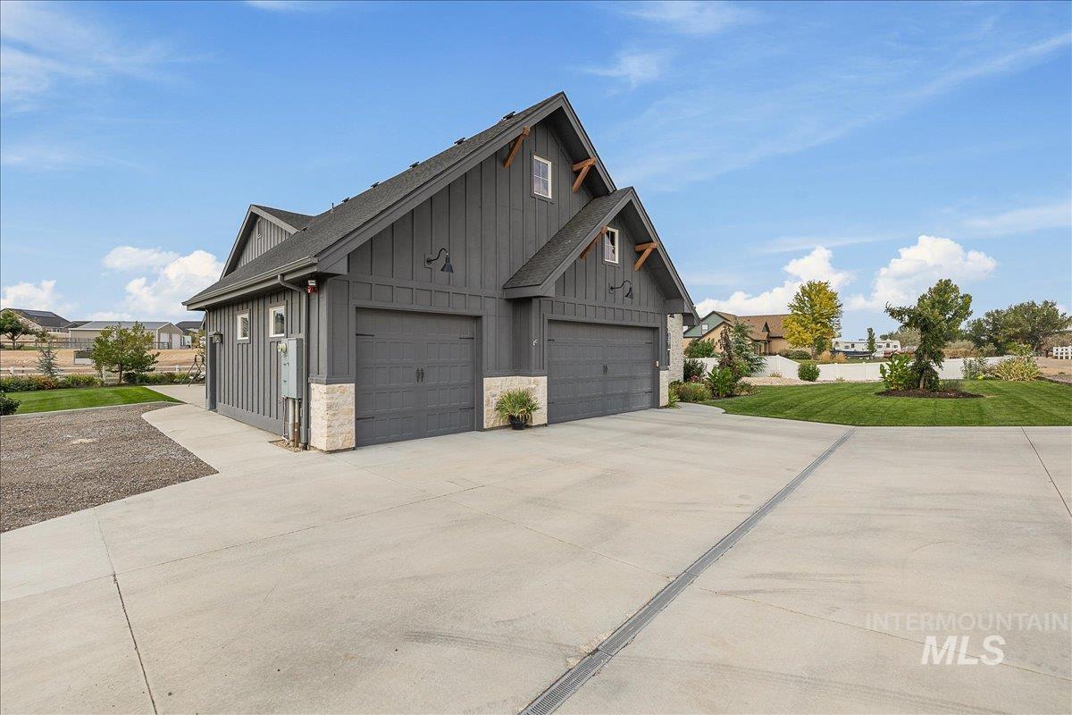 24301 Wanda Way Middleton, ID 83644 - Photo 41 of 50 View of property exterior featuring board and batten siding, driveway, a garage, and a yard