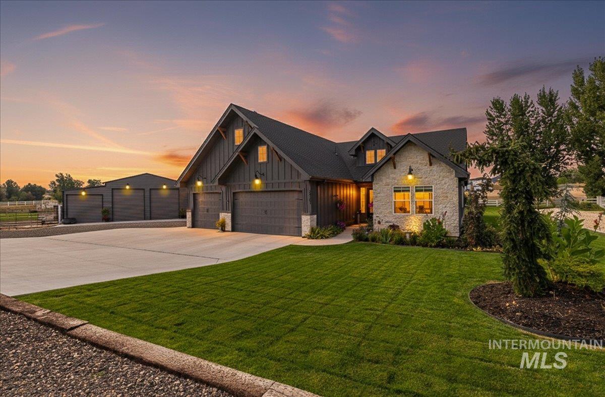 24301 Wanda Way Middleton, ID 83644 - Photo 47 of 50 View of front of property featuring stone siding, board and batten siding, driveway, a front yard, and a garage