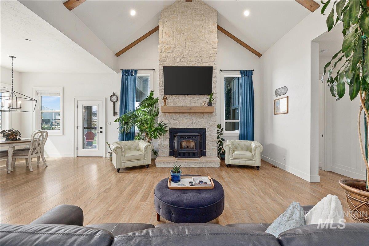 24301 Wanda Way Middleton, ID 83644 - Photo 10 of 50 Living room featuring light wood-style flooring, high vaulted ceiling, a fireplace, recessed lighting, and a chandelier