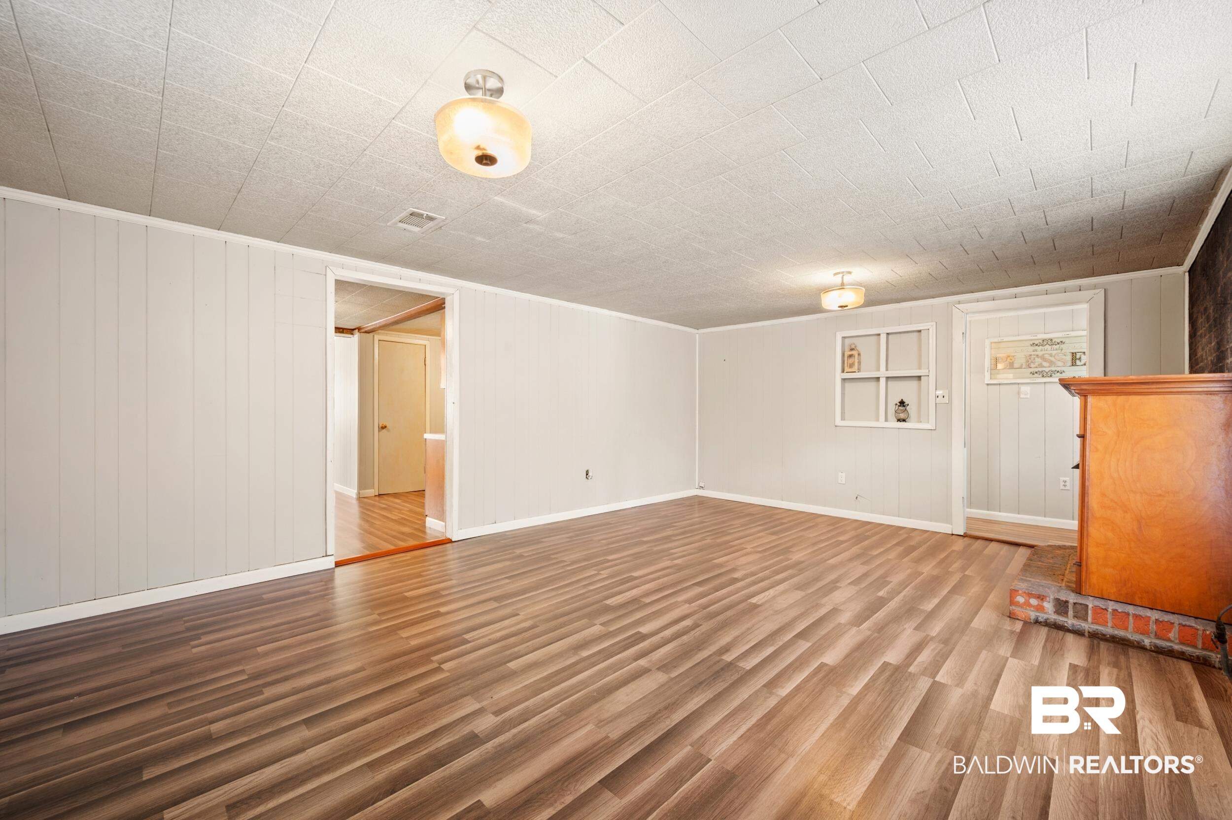 57623 Mary Hadley Road Perdido, AL 36562 - Photo 12 of 34 Unfurnished living room with light wood-type flooring and wood walls