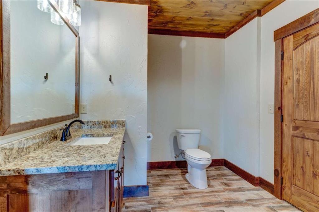 370 High Ridge Road Epworth, GA 30541 - Photo 26 of 42 a bathroom with a granite countertop sink and a toilet