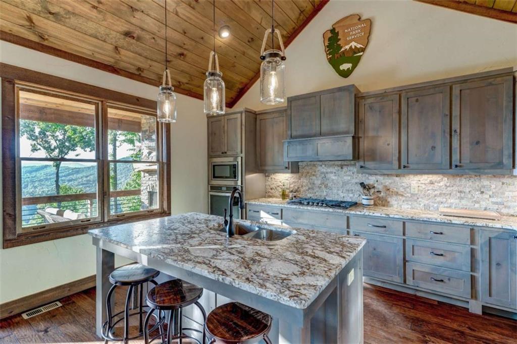 370 High Ridge Road Epworth, GA 30541 - Photo 8 of 42 a kitchen with granite countertop a table chairs a stove and wooden cabinets