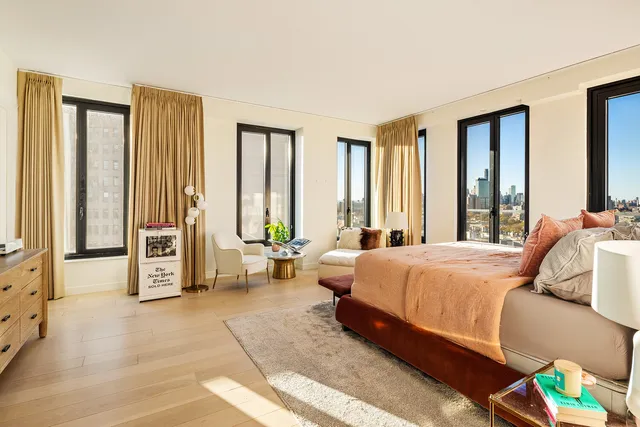 a bedroom with a bed couch and a large window