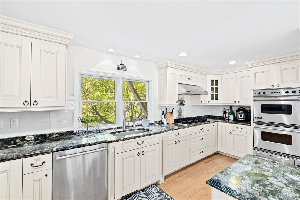 22 Beach Road Sharon, MA 02067 - Photo 10 of 27 a kitchen with granite countertop a sink a window stainless steel appliances and white cabinets
