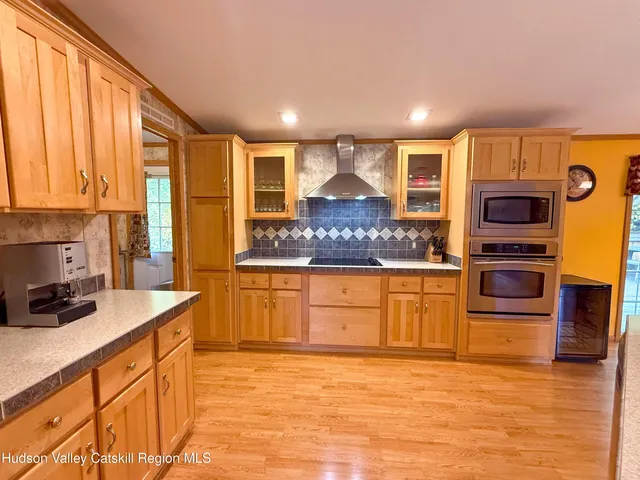 a kitchen with stainless steel appliances granite countertop a sink a stove and a wooden cabinets