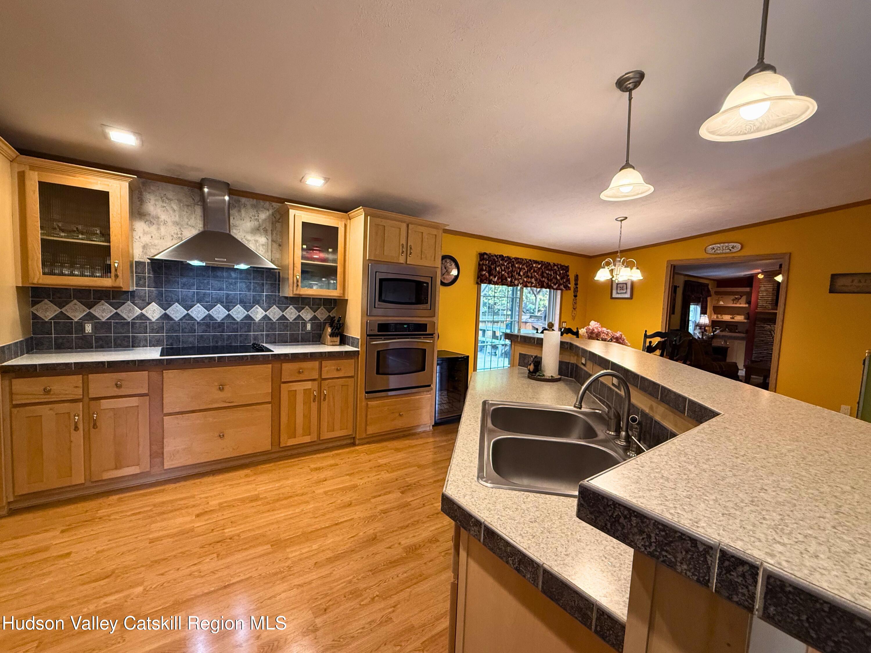 766 Hog Mountain Circle Fleischmanns, NY 12430 - Photo 13 of 31 a kitchen with stainless steel appliances granite countertop a sink a stove and a wooden cabinets