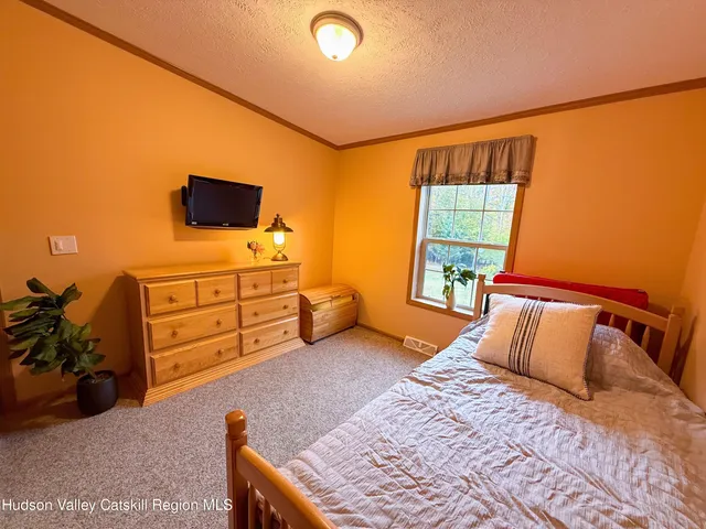a bedroom with a bed and flat screen tv