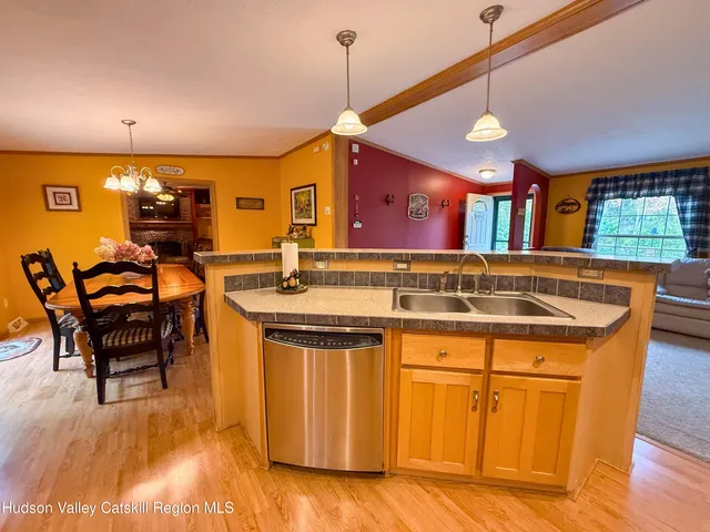 a open kitchen with stainless steel appliances kitchen island granite countertop a table chairs and a view of living room