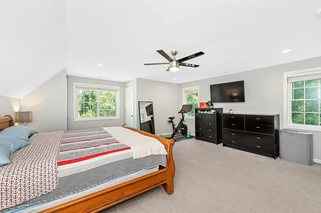 a bedroom with a bed a dresser and a flat screen tv