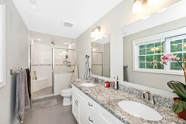 a bathroom with a granite countertop sink mirror toilet and shower