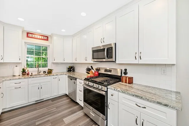 a kitchen with stainless steel appliances granite countertop a stove a sink and a microwave