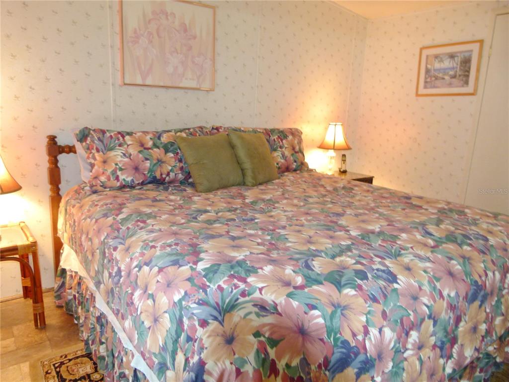 1017 1st Street Okeechobee, FL 34974 - Photo 18 of 36 a bedroom with a bed and chair