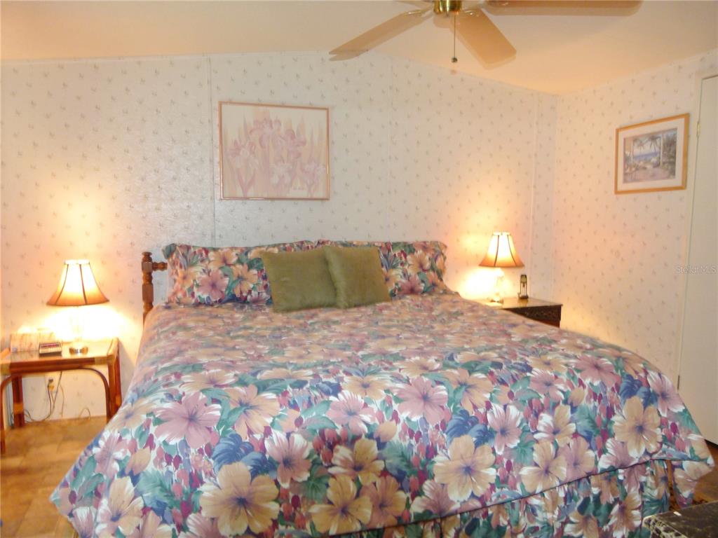 1017 1st Street Okeechobee, FL 34974 - Photo 19 of 36 a bedroom with a bed and a lamp with the dresser
