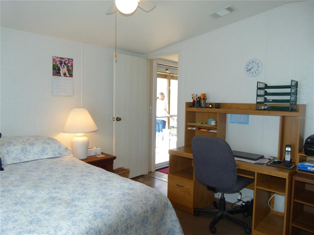 1017 1st Street Okeechobee, FL 34974 - Photo 22 of 36 a bedroom with a bed and a desk