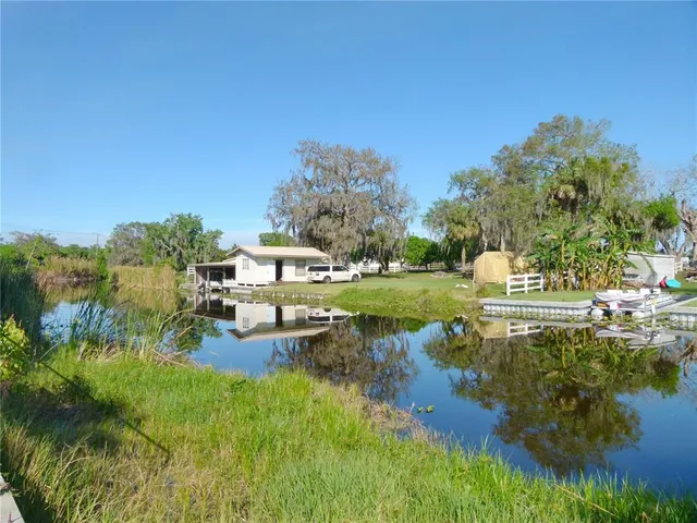 a aerial view of a house with a yard lake and outdoor seating