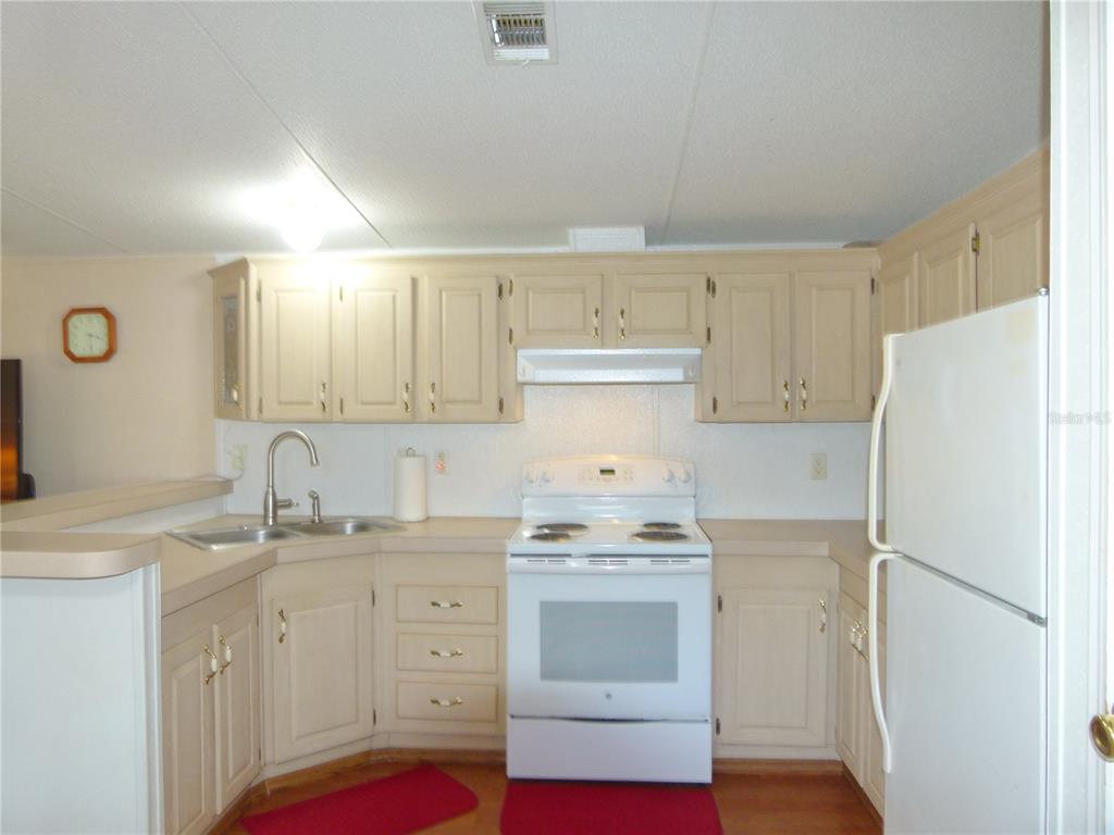 1017 1st Street Okeechobee, FL 34974 - Photo 9 of 36 a kitchen with white cabinets and white appliances