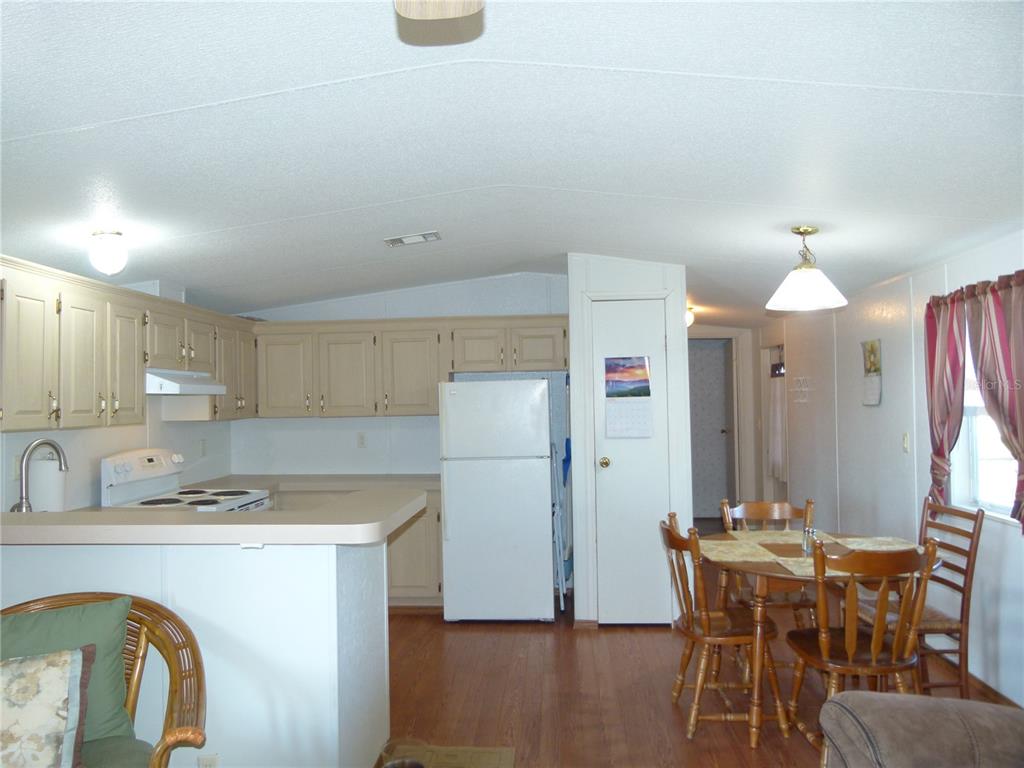1017 1st Street Okeechobee, FL 34974 - Photo 10 of 36 a kitchen with refrigerator a sink and chairs